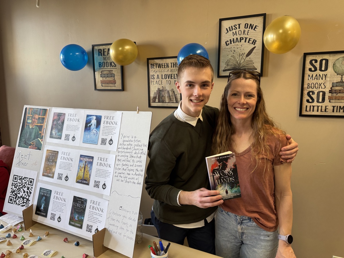 Xavier with his mom at his first book signing, holding Work of the Hands